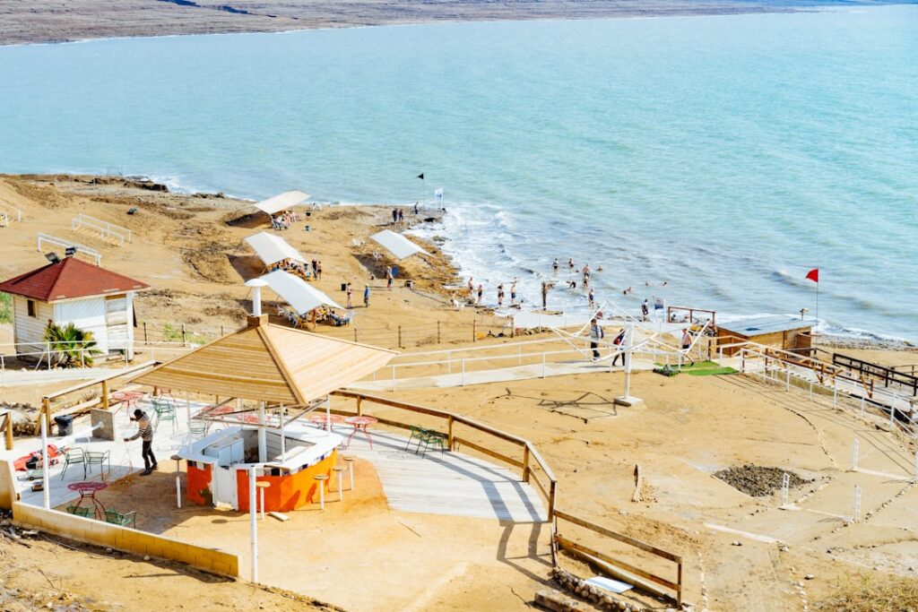 אוהל גלמפינג מרווח ומאובזר מול נוף ים המלח, עם מיטה נוחה ופינת ישיבה חיצונית.