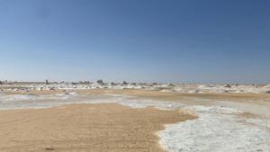 חאן בדואי מסורתי בלב המדבר השקט, עם נוף לים המלח וההרים מסביב, תחת שמיים בהירים.