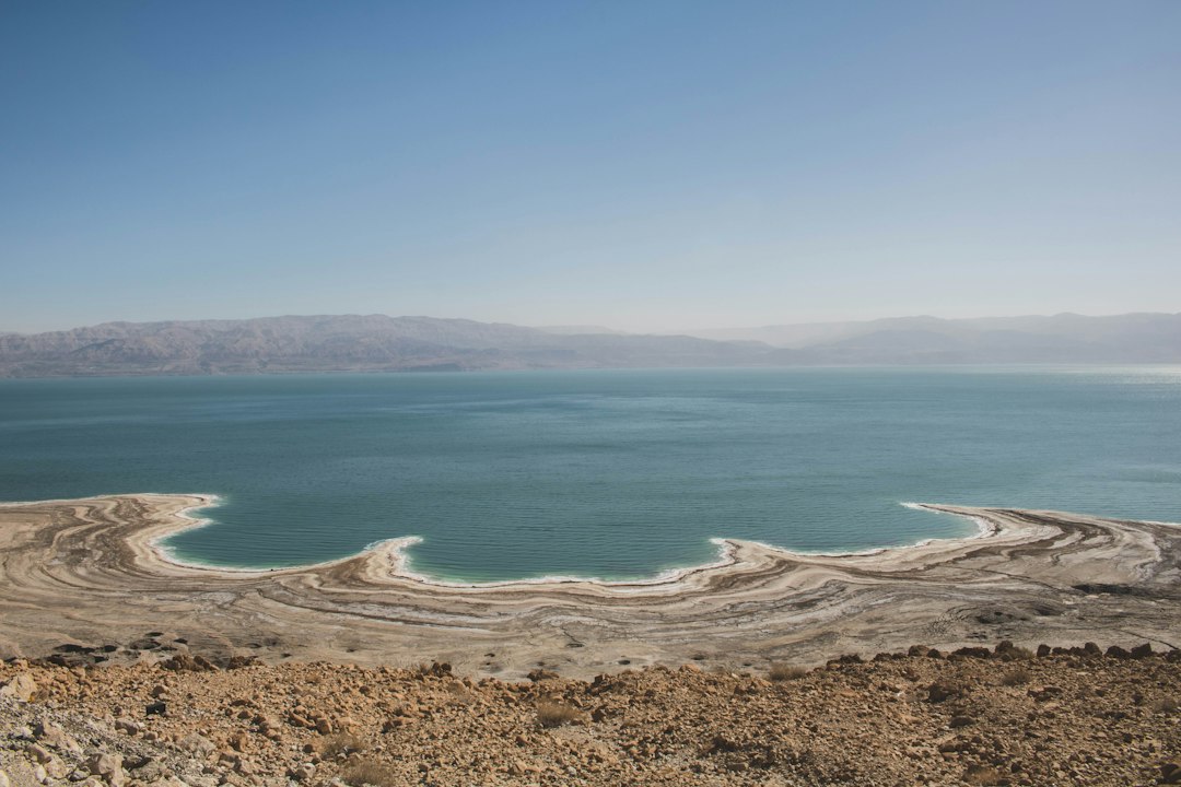 בור בולען עגול וברור בקרקע המדברית היבשה, עם שכבות אדמה גיאולוגיות חשופות סביבו.