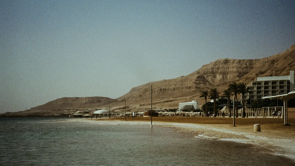 אדם יושב ליד שולחן ובוחן מפות ועלונים של מלונות ים המלח, מתכנן חופשה לפי תקציב ומטרה.